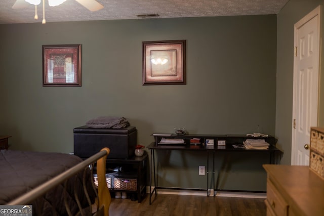 bedroom with a textured ceiling, ceiling fan, and wood-type flooring