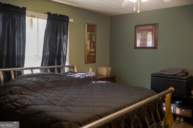 bedroom with ceiling fan and a textured ceiling