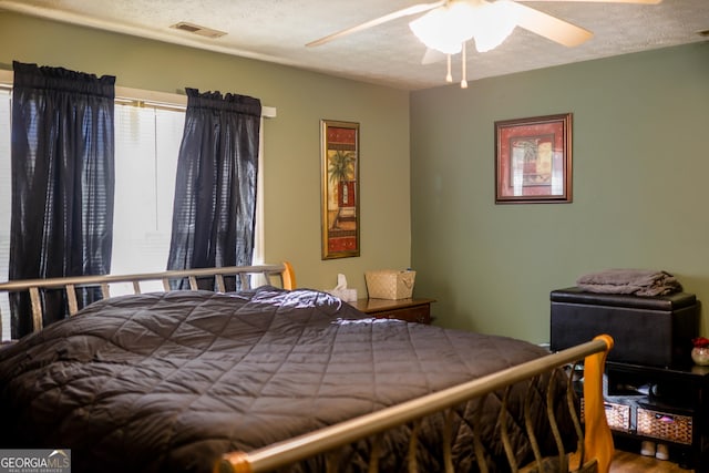 bedroom with a textured ceiling and ceiling fan