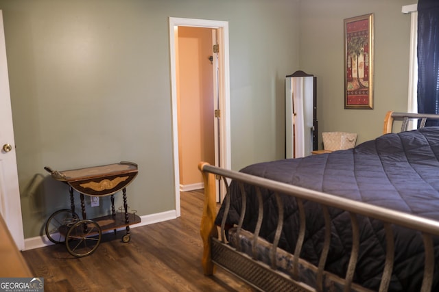 bedroom with dark hardwood / wood-style flooring