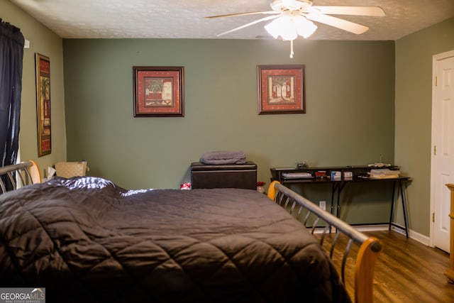 bedroom with ceiling fan, a textured ceiling, and hardwood / wood-style flooring