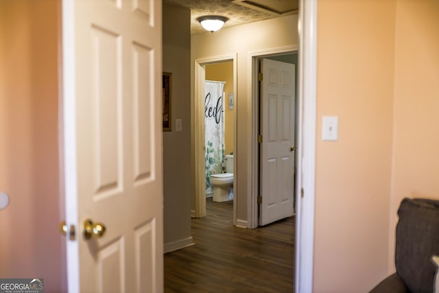 hallway featuring a textured ceiling and dark hardwood / wood-style floors