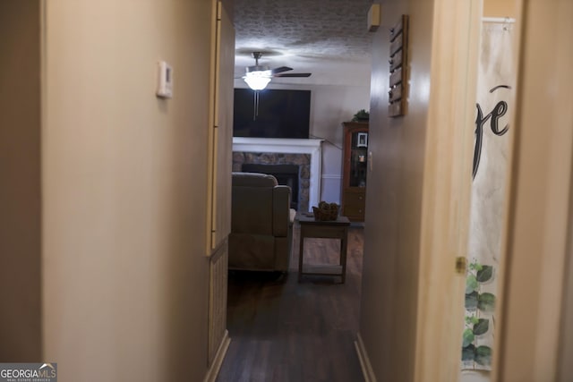 hallway with wood-type flooring and a textured ceiling