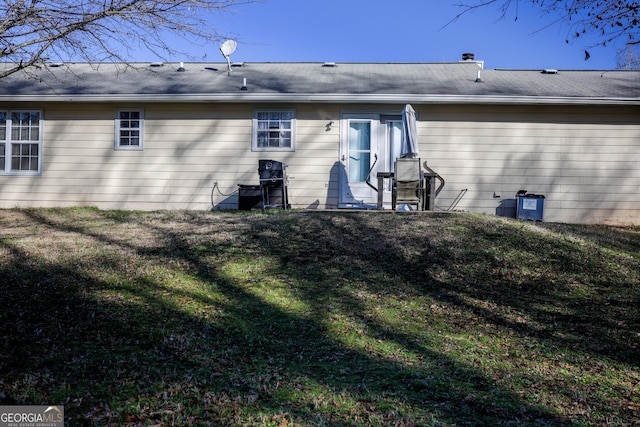 rear view of property featuring a yard