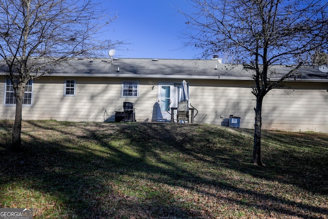 rear view of house featuring a lawn