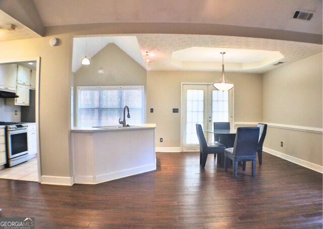 kitchen featuring white cabinetry, range, stainless steel fridge, and dark tile patterned flooring