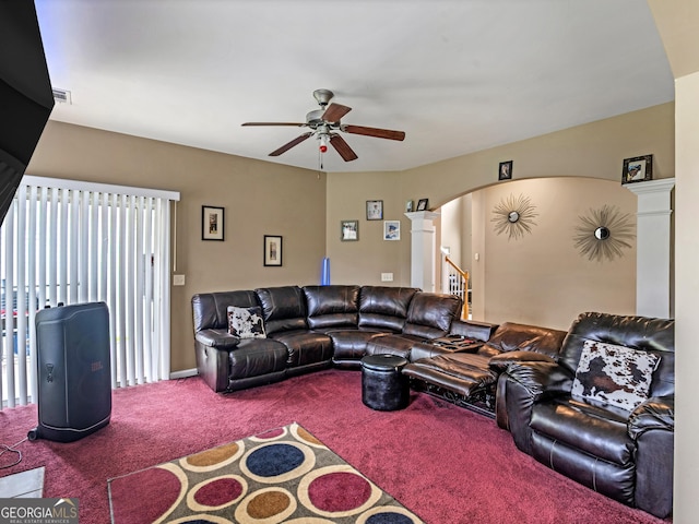 carpeted living room with ceiling fan and ornate columns