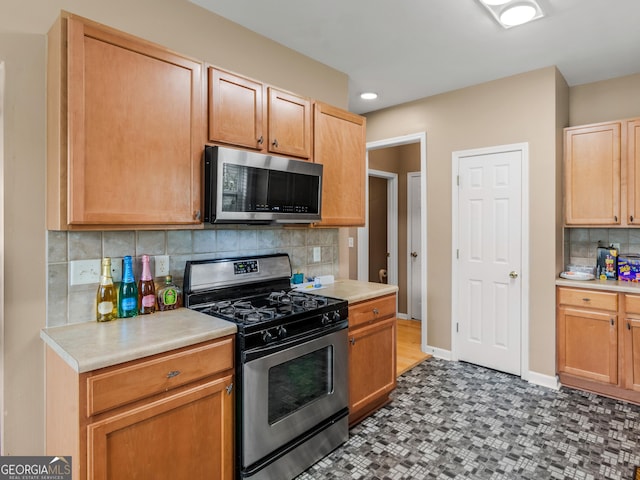 kitchen with stainless steel appliances and tasteful backsplash