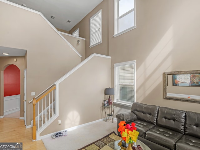 living room with plenty of natural light, hardwood / wood-style floors, and a towering ceiling