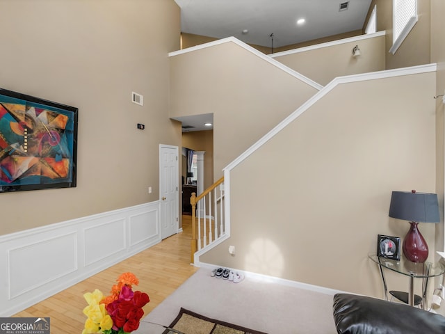 staircase featuring a high ceiling and hardwood / wood-style flooring