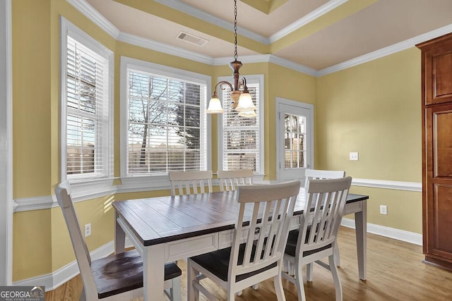 dining area with light wood-style floors, visible vents, crown molding, and baseboards