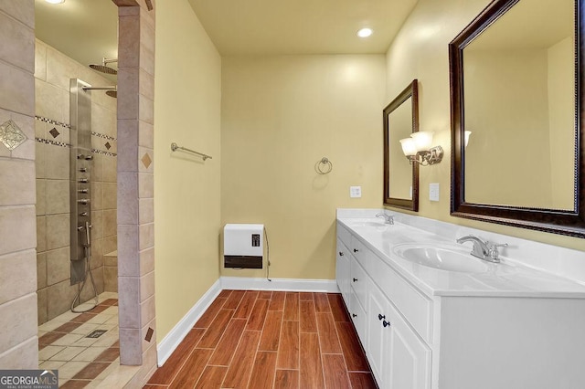 full bathroom featuring wood tiled floor, baseboards, a walk in shower, and a sink