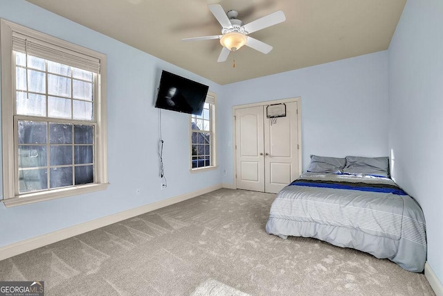 unfurnished bedroom featuring carpet, baseboards, ceiling fan, and a closet