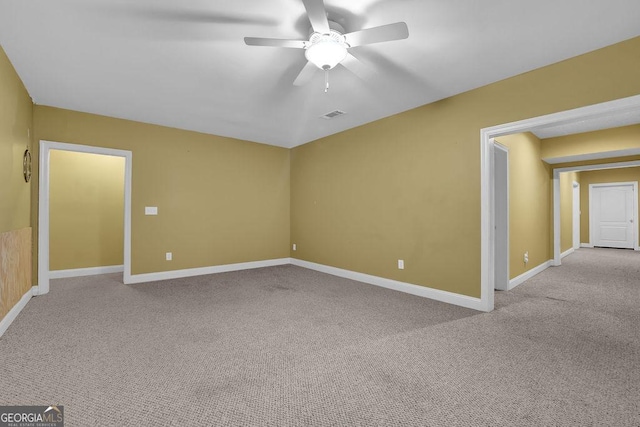 carpeted empty room with visible vents, ceiling fan, and baseboards