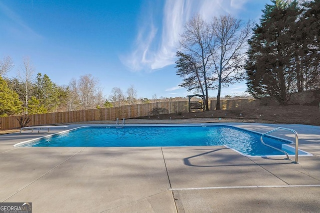 view of swimming pool featuring a fenced in pool, a patio area, a fenced backyard, and a diving board