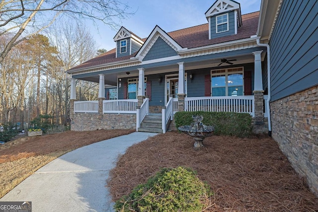 craftsman-style house with stone siding, a shingled roof, and a porch