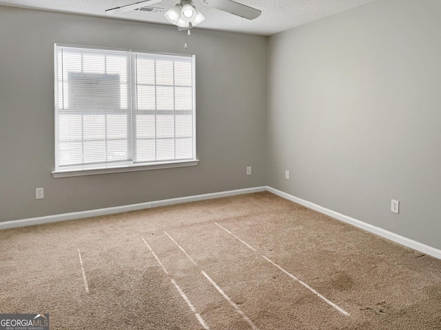 carpeted empty room featuring ceiling fan and a textured ceiling