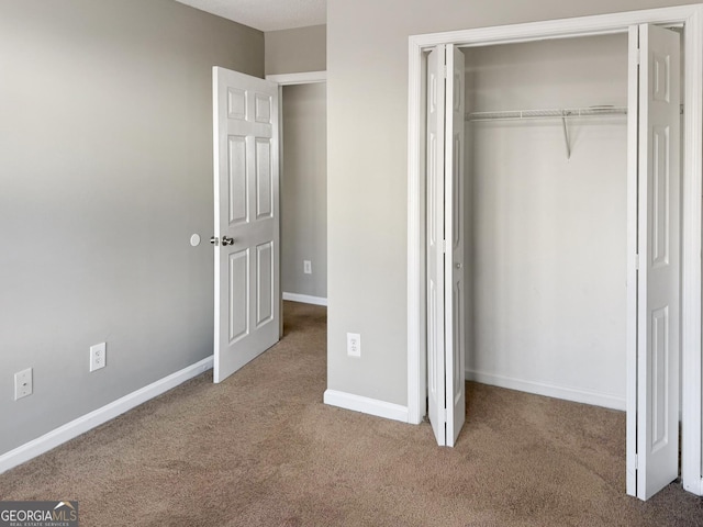 unfurnished bedroom with a closet and carpet flooring