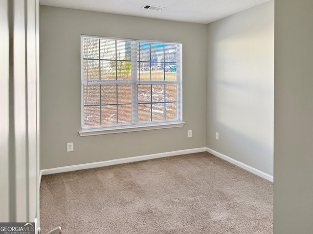 carpeted empty room with a textured ceiling