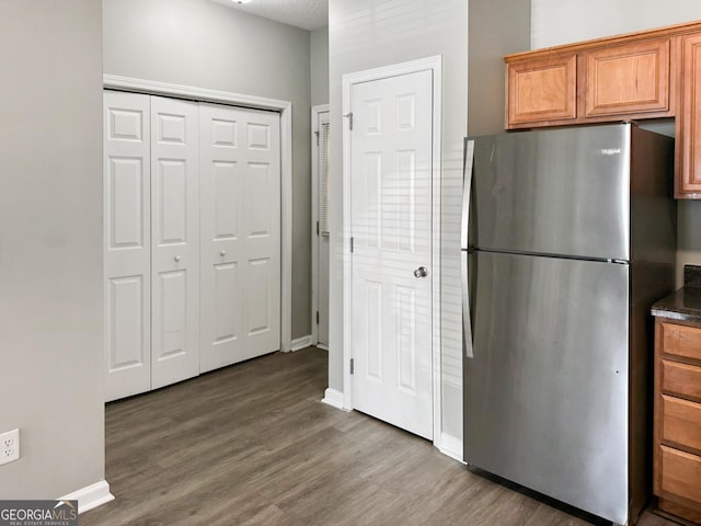 kitchen featuring wood-type flooring and stainless steel fridge