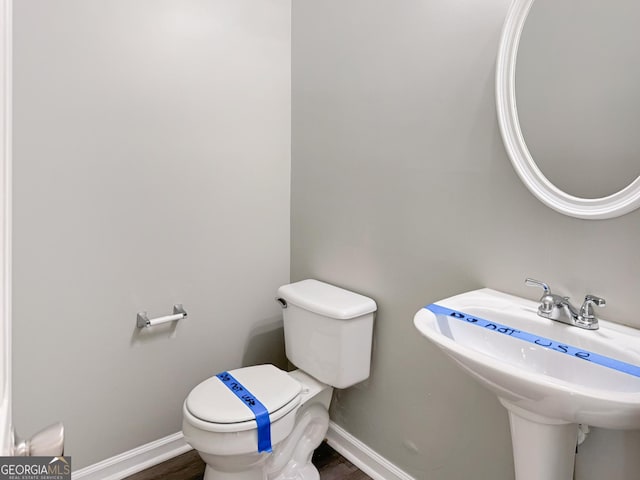 bathroom with toilet, hardwood / wood-style flooring, and sink