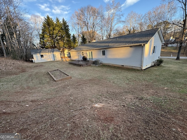 rear view of property with a storage shed, a yard, and central air condition unit