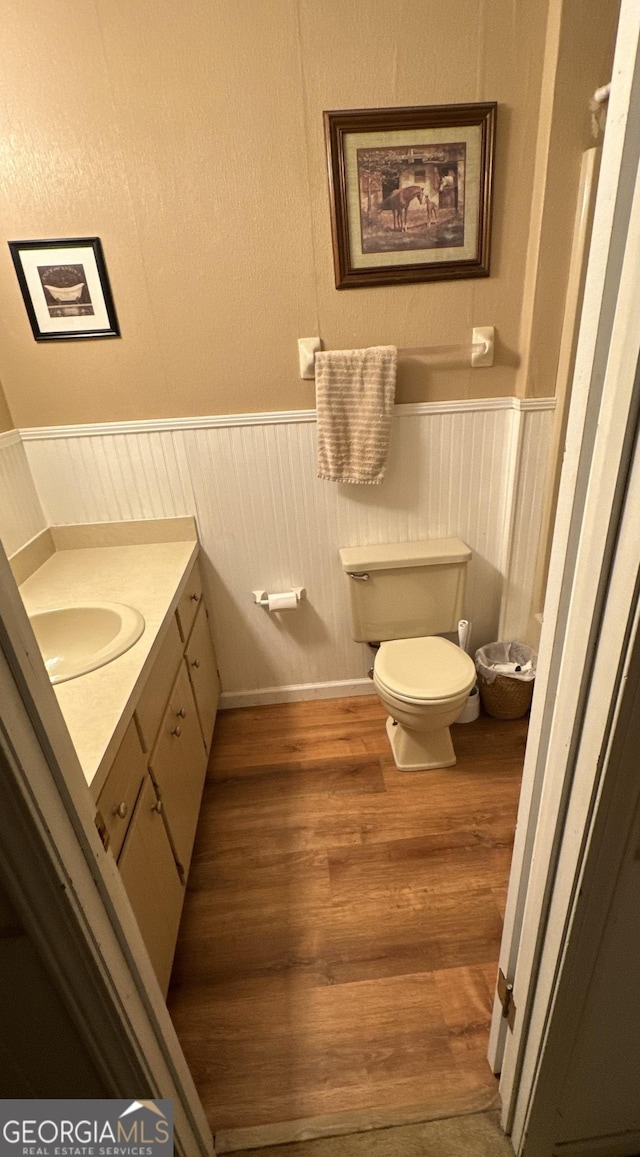 bathroom with wood-type flooring, vanity, and toilet