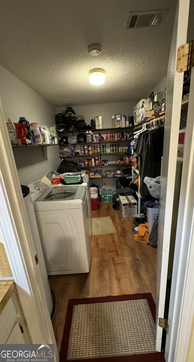 interior space with washer and clothes dryer, hardwood / wood-style floors, and a textured ceiling