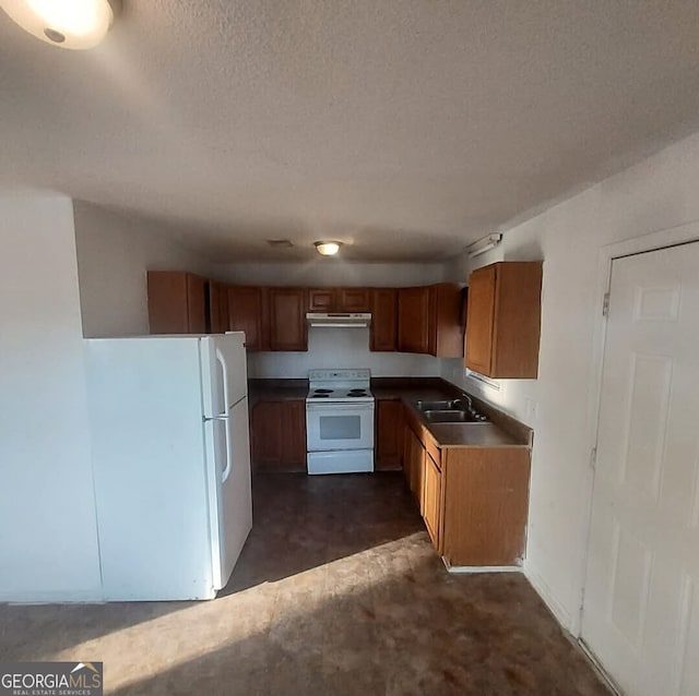 kitchen featuring sink, white appliances, and a textured ceiling