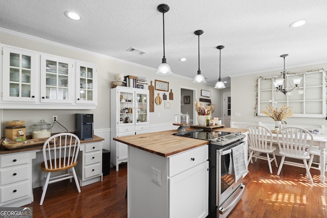 kitchen featuring stainless steel range with electric cooktop, butcher block counters, hanging light fixtures, white cabinets, and a center island