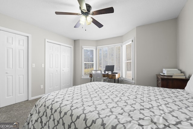 bedroom featuring ceiling fan, carpet, and two closets