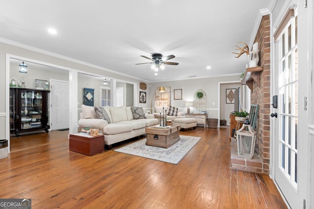 living room with ceiling fan, ornamental molding, and hardwood / wood-style flooring