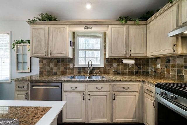 kitchen with stainless steel appliances, wall chimney range hood, backsplash, and sink