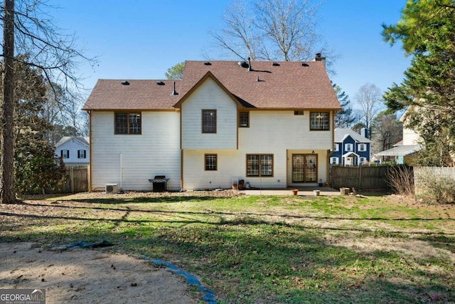 rear view of property with a lawn, central AC unit, and a patio area