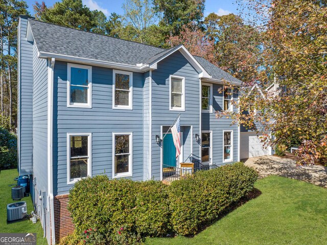 view of front of property with central AC unit and a garage