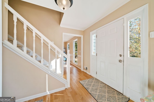 entryway featuring ornamental molding and hardwood / wood-style floors