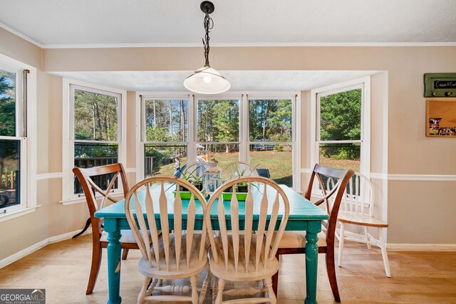 dining area with ornamental molding, hardwood / wood-style floors, and a textured ceiling