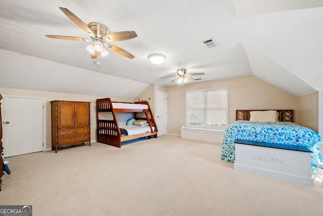 bedroom with light colored carpet, lofted ceiling, and a textured ceiling