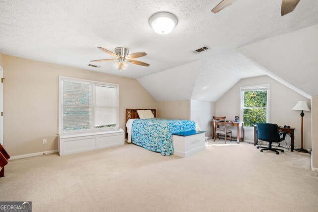 carpeted bedroom featuring ceiling fan, vaulted ceiling, and a textured ceiling