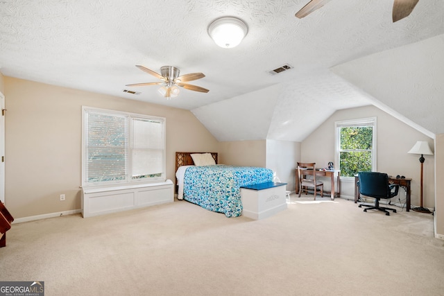 bedroom featuring lofted ceiling, carpet floors, and a textured ceiling