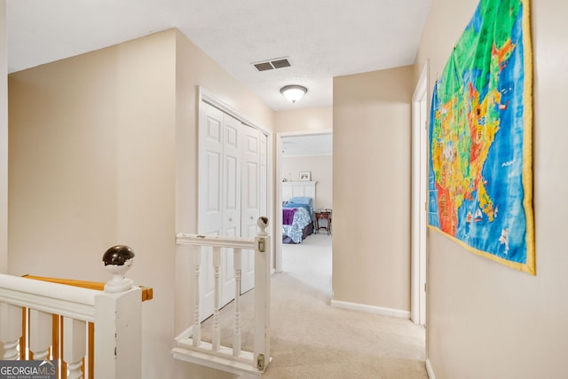 hall with carpet flooring and a textured ceiling