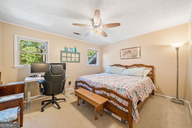 bedroom featuring ceiling fan, ornamental molding, light colored carpet, and a textured ceiling