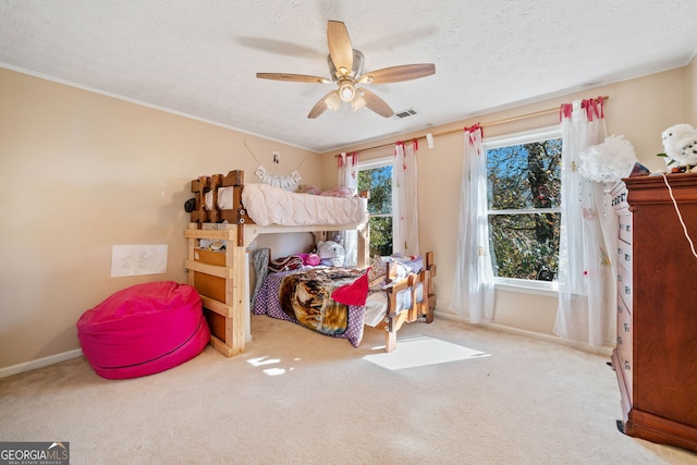 carpeted bedroom with ceiling fan, multiple windows, and a textured ceiling