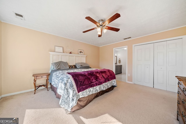 carpeted bedroom featuring connected bathroom, a closet, and ceiling fan