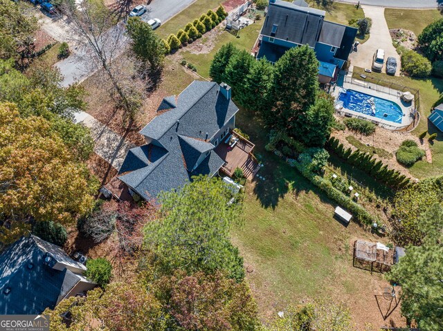 rear view of property featuring a wooden deck, a sunroom, and a lawn