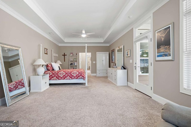 bedroom featuring ceiling fan, multiple windows, a tray ceiling, and access to outside