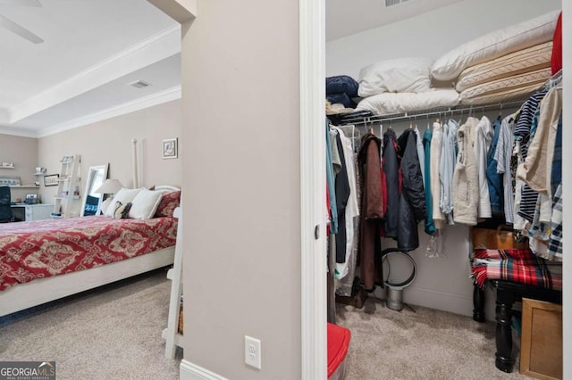 bedroom featuring light carpet, ceiling fan, a closet, and ornamental molding