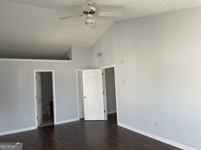 unfurnished bedroom featuring a textured ceiling, dark hardwood / wood-style flooring, vaulted ceiling, ceiling fan, and ensuite bathroom