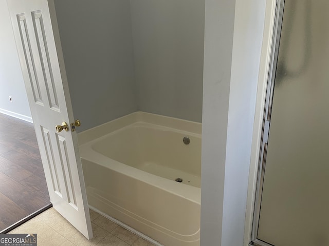 bathroom with a bath and tile patterned floors