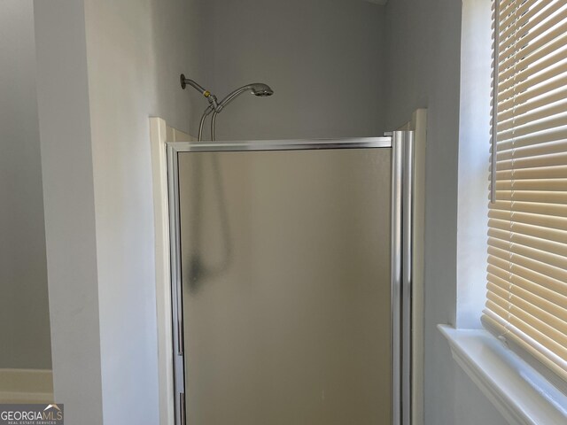 bathroom featuring an enclosed shower and plenty of natural light